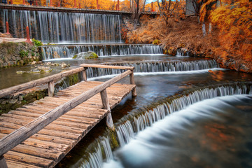 wooden terrace bridge in flowing waterfall