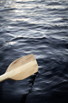 closeup of a canoe paddle rowing on a lake