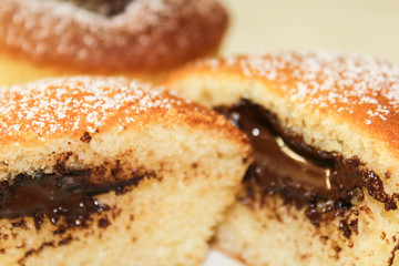Two muffins with chocolate. One cut to half on white background, close up photo.