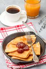 Breakfast. Crepes. Thin pancakes with strawberry jam. Selective focus