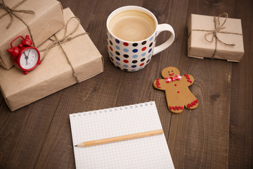 Coffee, notebook and wrapped gifts on the table
