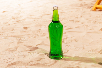 Orange wood box and lemonade bottles in summer sunny time on beach of ocean with palm leaves useful for background