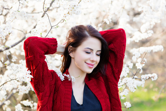 beautiful young woman standing in front of wonderful blooming trees