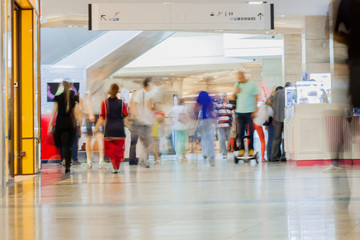 Obraz premium Abstract defocused motion blurred walking young people, active lifestyle in the shopping center, urban lifestyle concept, background.