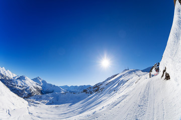 Snow-covered mountains panorama with ski slopes