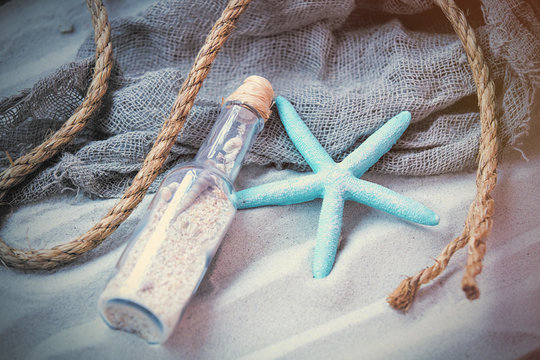 beautiful souvenir, starfish, rope and cool fishnet lying on the wonderful beach sand background