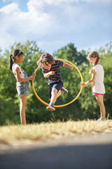 Junge springt durch Hula Hoop Reifen