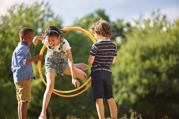 Mädchen springt durch Hula Hoop Reifen