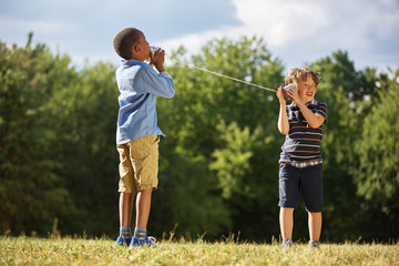 Zwei Jungen spielen mit Dosentelefon