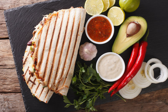 Mexican quesadilla with beef, beans, avocado and cheese close-up. Horizontal top view