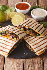 Mexican quesadilla with ground beef, spinach and cheddar cheese close-up. vertical