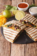 quesadilla with meat, spinach and cheddar cheese close-up. vertical