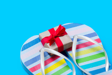colorful sandals and cute small gift on the wonderful blue background