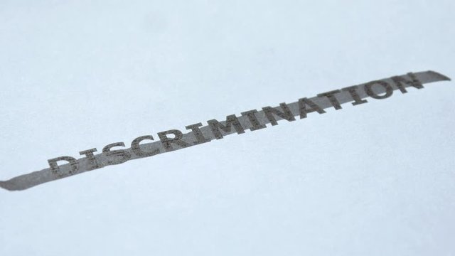 Man hand crosses out the word Discrimination with black marker. Stop discrimination