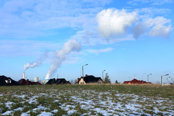 Dachy domów, dymiące kominy elektrowni. © Stanisław Błachowicz