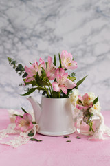 Pink flowers in a teapot on a light background