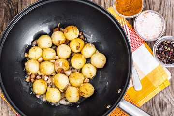 Fried potato dumplings with bacon in frying pan