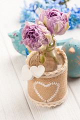 Purple tulips in bottle with hearts