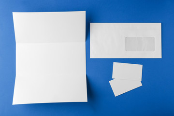 Blank brochure, envelope and card on blue background