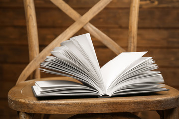 Chair with new book on wooden background