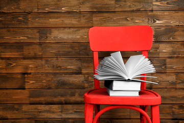 Obraz premium Chair with new books on wooden background