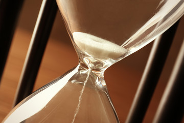Black hourglass with white sand, closeup