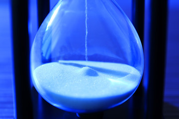 Hourglass with white sand, closeup