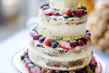 Delicious chocolate wedding cake decorated with fruits and berries