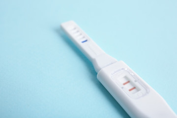 Pregnancy test on turquoise background