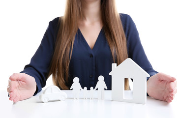 Woman with model of house, car and family on white table
