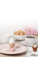 Handmade Natural Linen Napkin With Handmade Cross Stitching. Hyacinth Flowers. Amaretti Biscuits. Boiled Egg. Cup Of Tea
