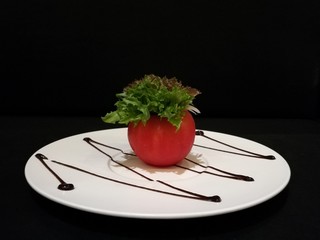 Healthy tomato salad stuff with lettuce and tuna on white plate, stylistfood, fusion food, black...