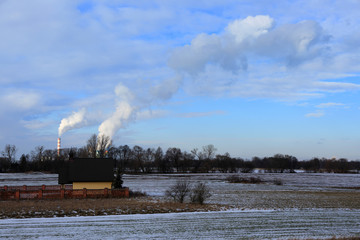 Dymiące kominy elektrowni, pola, domy jednorodzinne. © Stanisław Błachowicz