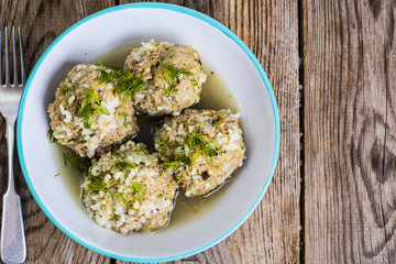 Meatballs meat with the rice grains in a blue ceramic bowl