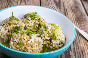 Meatballs meat with the rice grains in a blue ceramic bowl