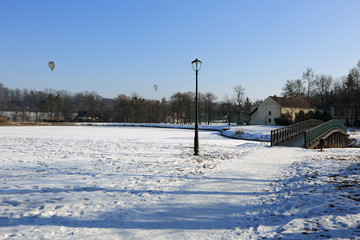 Piękny park zimą, most, latarnie i lot balonem.