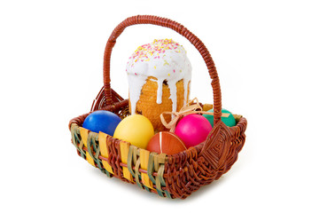 Easter eggs and cake in the wicker basket.