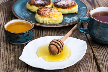 Cottage cheese pancakes on vintage plate on  background old boar