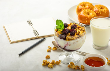 Delicious and healthy breakfast of granola, buns brioche, honey and milk on a light background . Soft fokus.