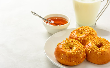 Delicious and healthy breakfast of  brioche buns with milk and honey on a light background. Copy space, soft fokus.