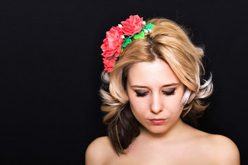 Woman with blond curls and stacking rim close-up on dark background looking down