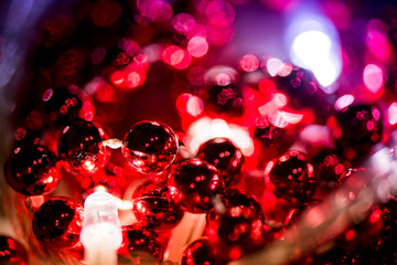 Abstract, blurry, vibrant and colorful background. A shot of Christmas decorations and lights on a lit Christmas Tree. Celebrations, holidays, family together, warmth in hearts. Champagne and lights.