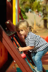 Cute baby boy climbing rope net or ladder