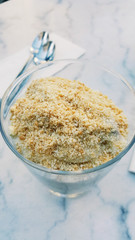 Banana Pudding with Hazelnut powder on marble surface.