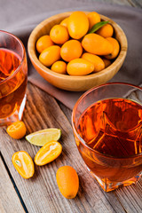 orange kumquat  liqueur in the  glasses on the wooden rustic  table