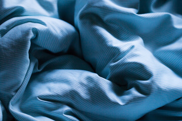 Sleeping blue bed sheet covered in morning or evening gentle sun light as relaxation romantic background