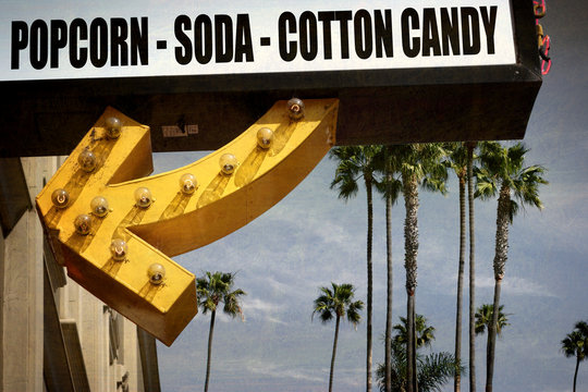 Aged And Worn Vintage Photo Of Popcorn Soda And Cotton Candy Sign With Arrow And Palm Trees