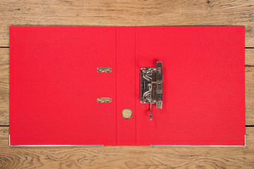 Open empty red folder for storage of documents lying on a wooden table