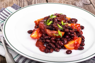 Red beans, tomatoes, ketchup, onion and spices on the white plat