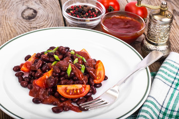 Red beans, tomatoes, ketchup, onion and spices on the white plat